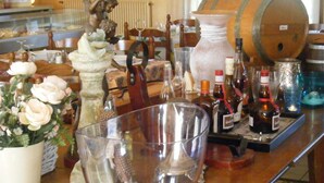 A bar area with a variety of bottles, a large wooden barrel, and a statue of an angel.