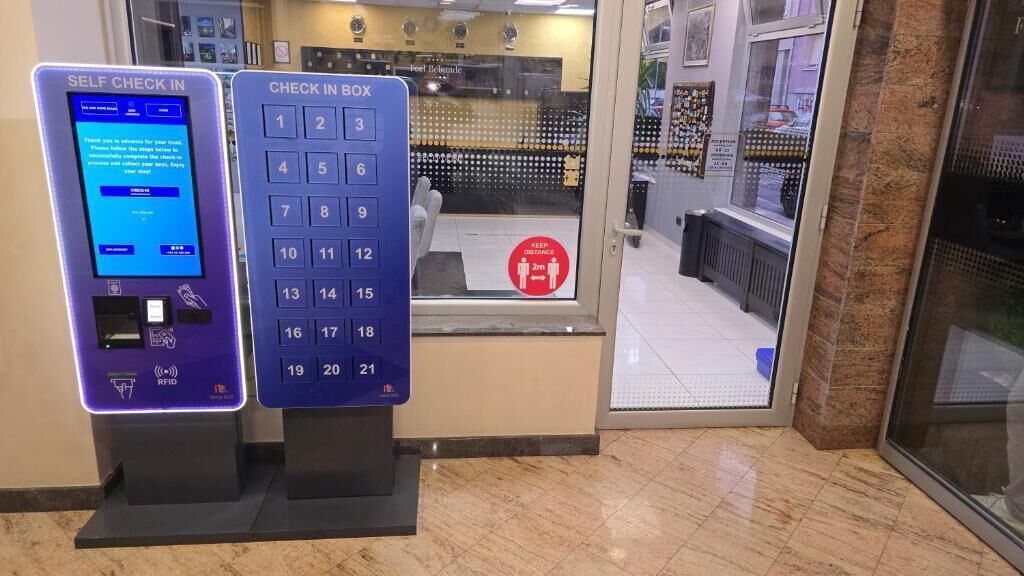 A self-check-in kiosk and a check-in box at a hotel entrance.