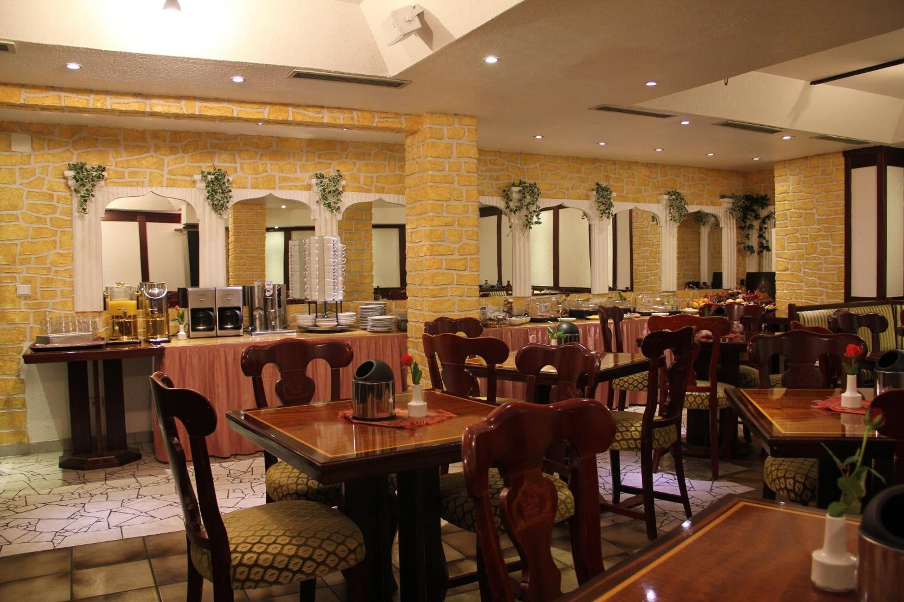 Un restaurante con paredes de piedra, varias mesas y sillas.