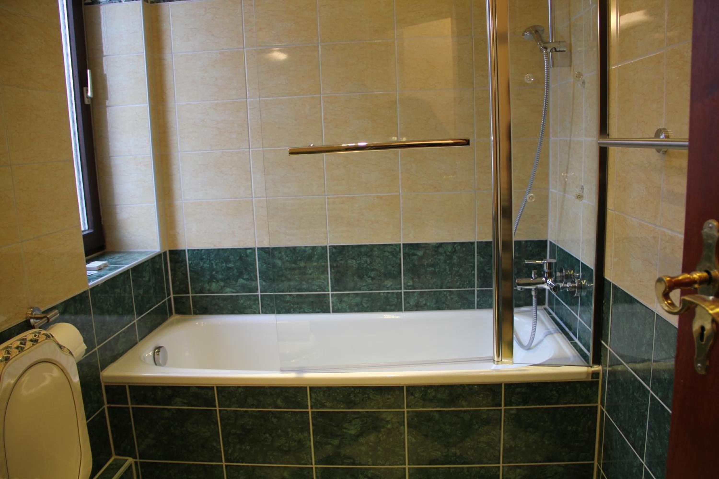 Ein Badezimmer mit Badewanne, Dusche und Toilette.