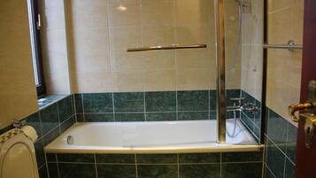 Ein Badezimmer mit Badewanne, Dusche und Toilette.