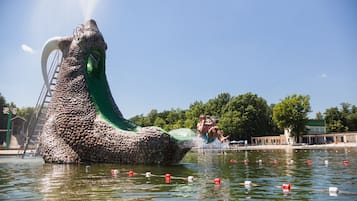 Una gran escultura de agua con un tobogán y una persona saltando al agua.