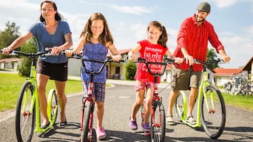 A family of four on bicycles on a paved path.