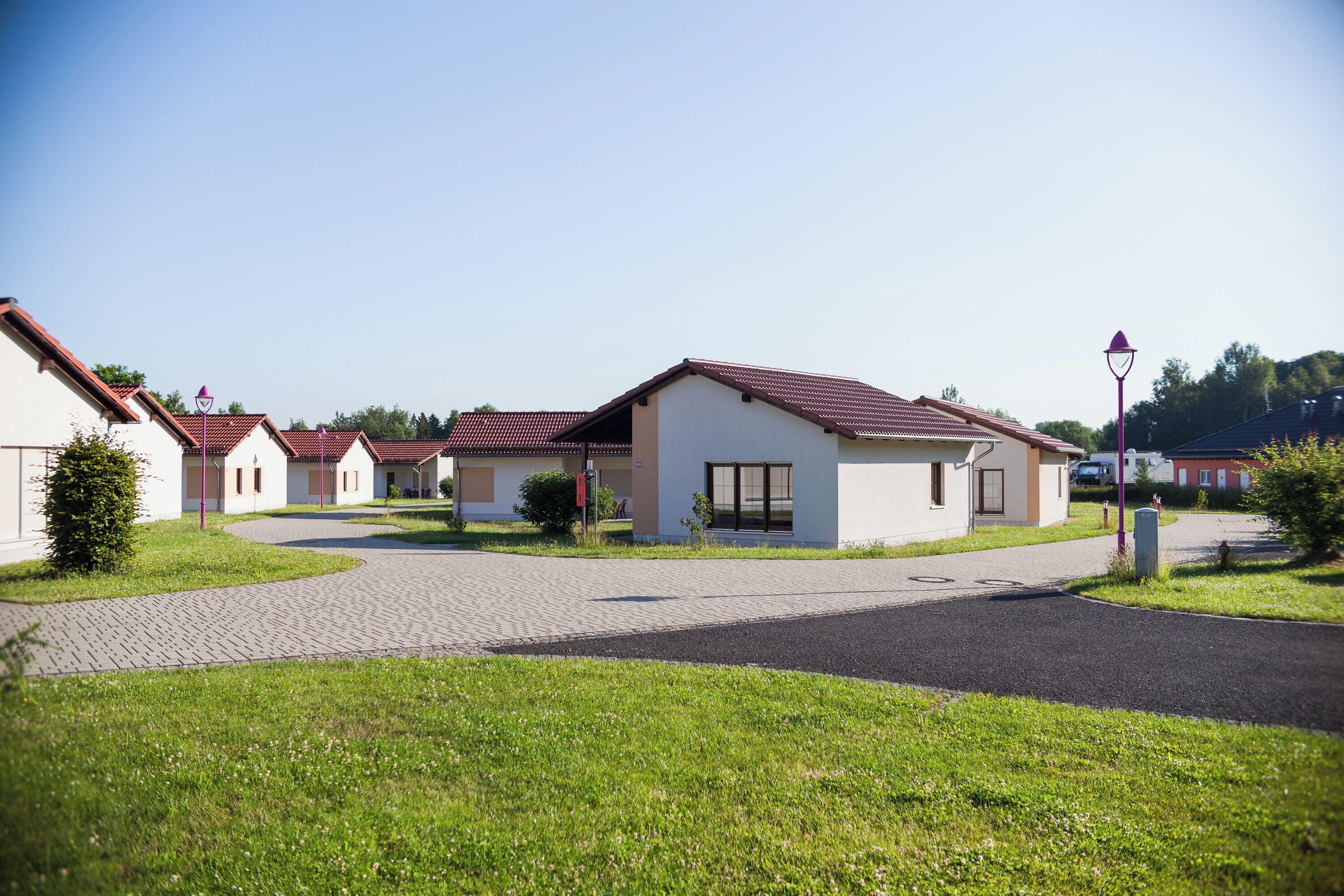 A residential area with houses, paved pathways, and greenery.