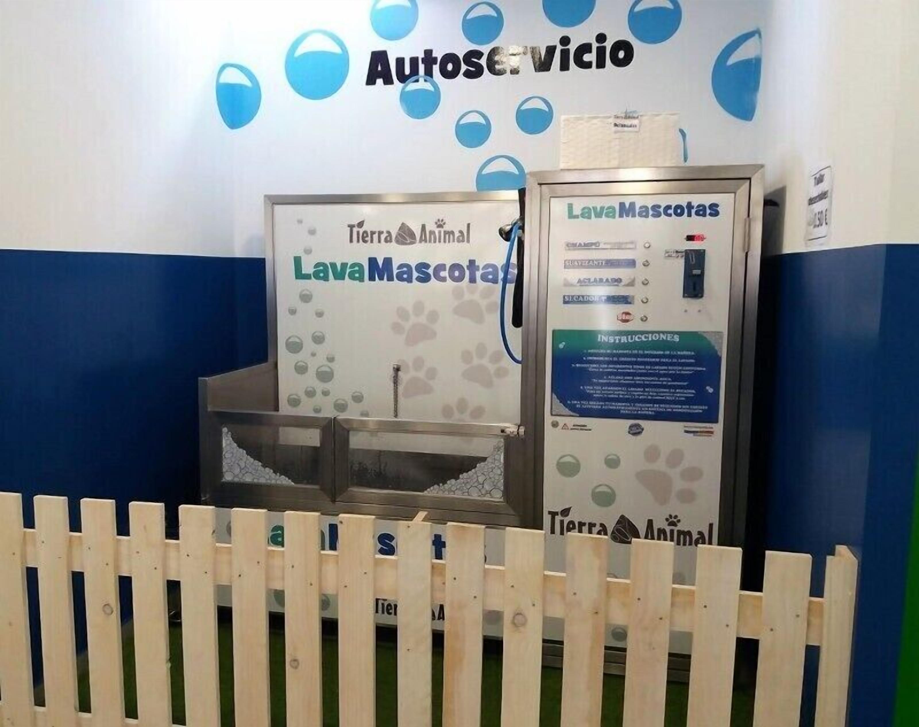 Zona de cuidado de mascotas con una estación de lavado para animales y un letrero que dice 'LavaMascotas'.