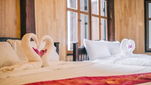 A hotel room with a bed, pillows, and a red blanket. - Heun At Fahham (Chiang Mai)