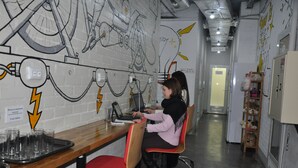 A workspace with a long table, chairs, and a wall with mechanical drawings. - Z Hostel (Kyiv)