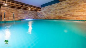 Una piscina interior con agua cristalina y paredes con textura.