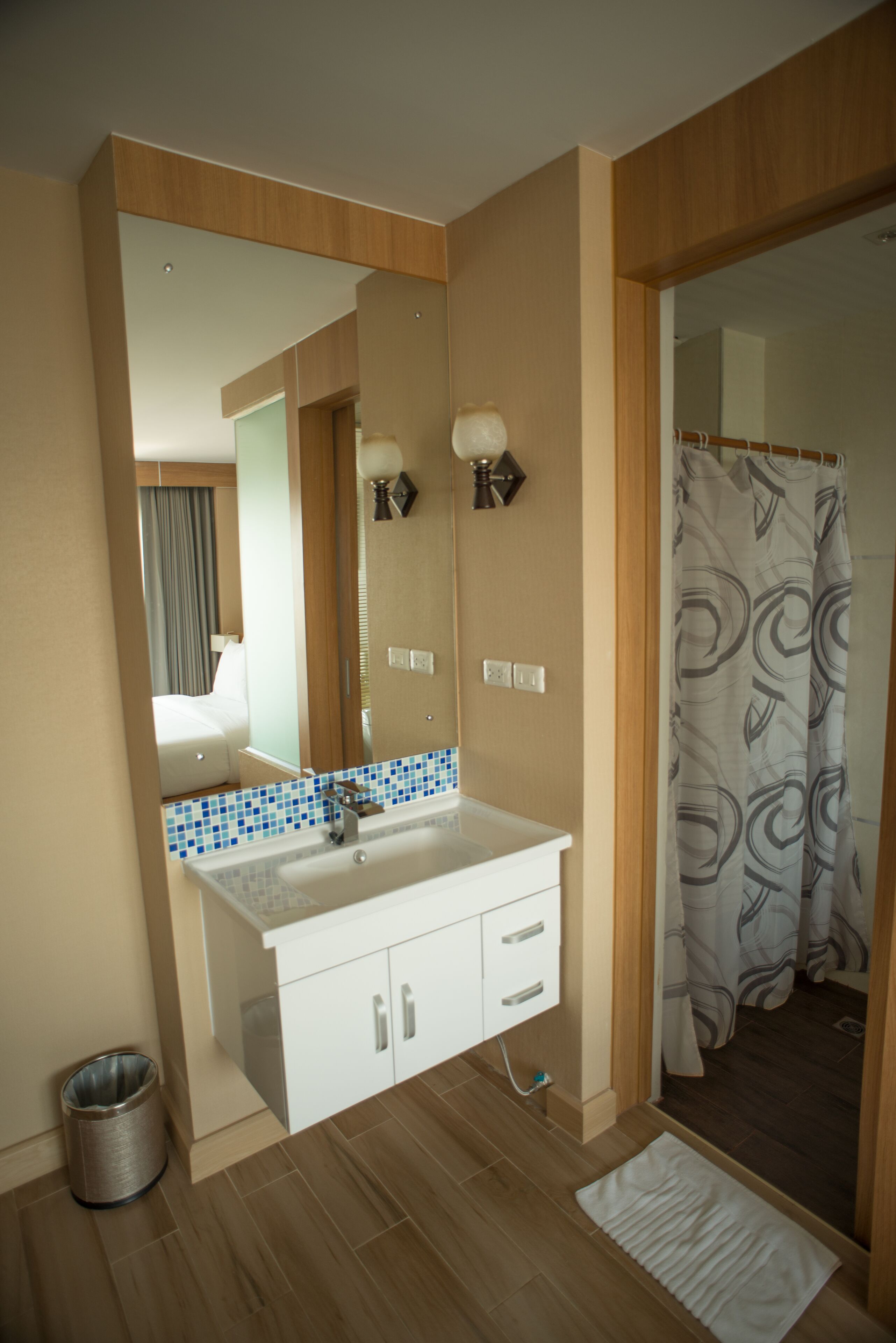 A modern bathroom with a white vanity, a mirror, and a shower curtain.