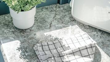 A kitchen counter with a potted plant, a toaster, and a checkered cloth.