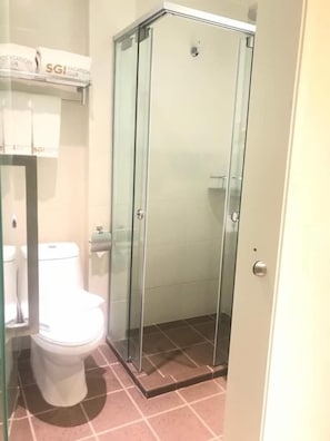 A bathroom with a glass-enclosed shower, a toilet, and a towel rack with a sign above it. - SGI Vacation Club Melaka (Malacca City)