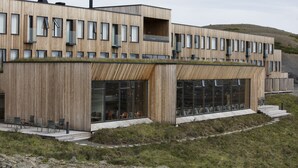 A modern building with a wooden facade, large windows, and a flat roof. - Fosshotel Myvatn (Myvatn)