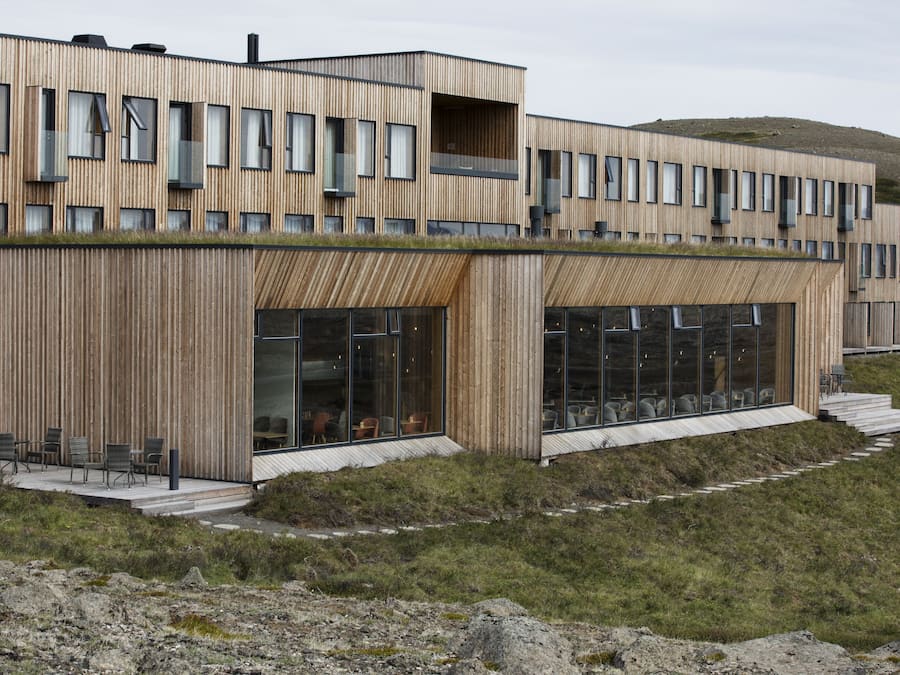 A modern building with a wooden facade, large windows, and a flat roof.