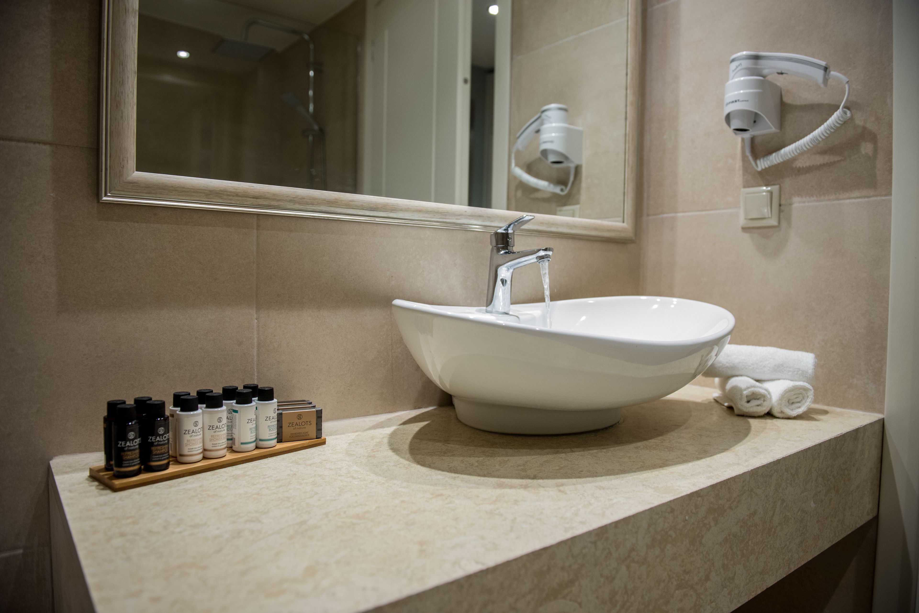 Une salle de bain avec un lavabo blanc, un miroir et un porte-serviettes.