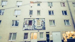 Um edifício com vários andares, com muitas janelas e uma porta no andar térreo.