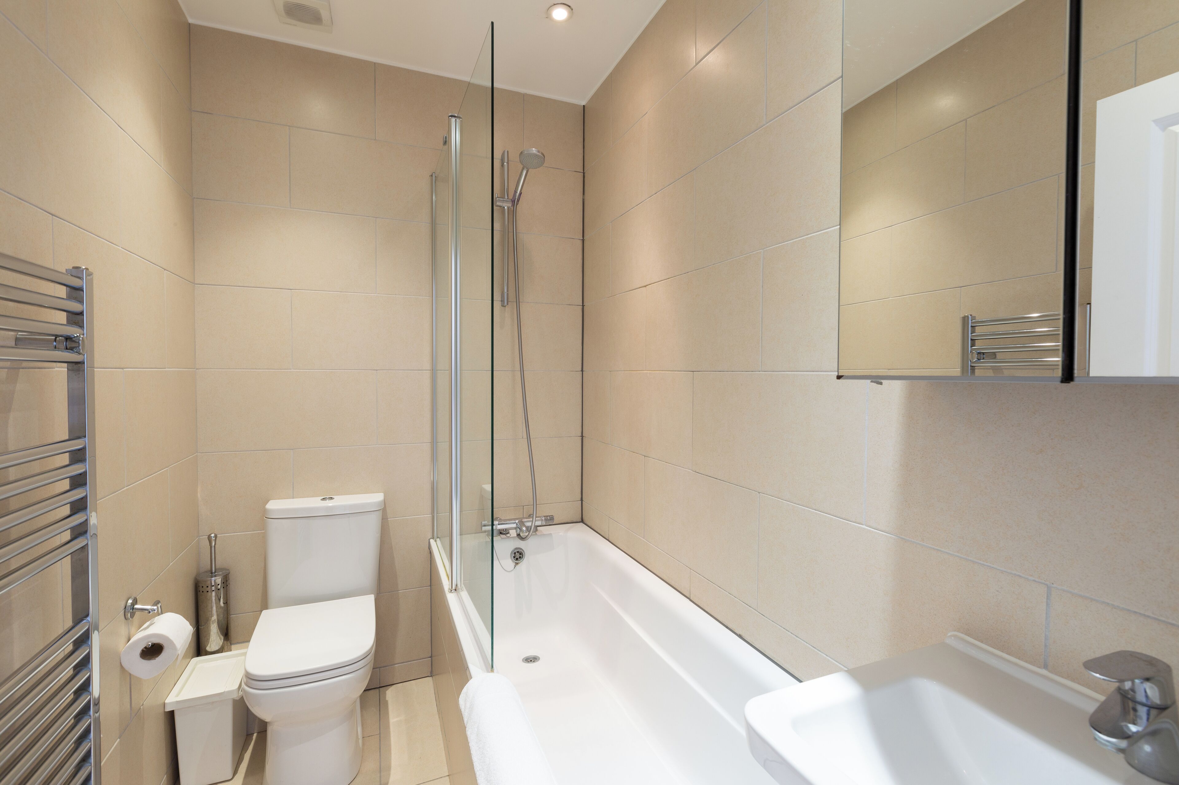 Een moderne badkamer met toilet, douche en bad.