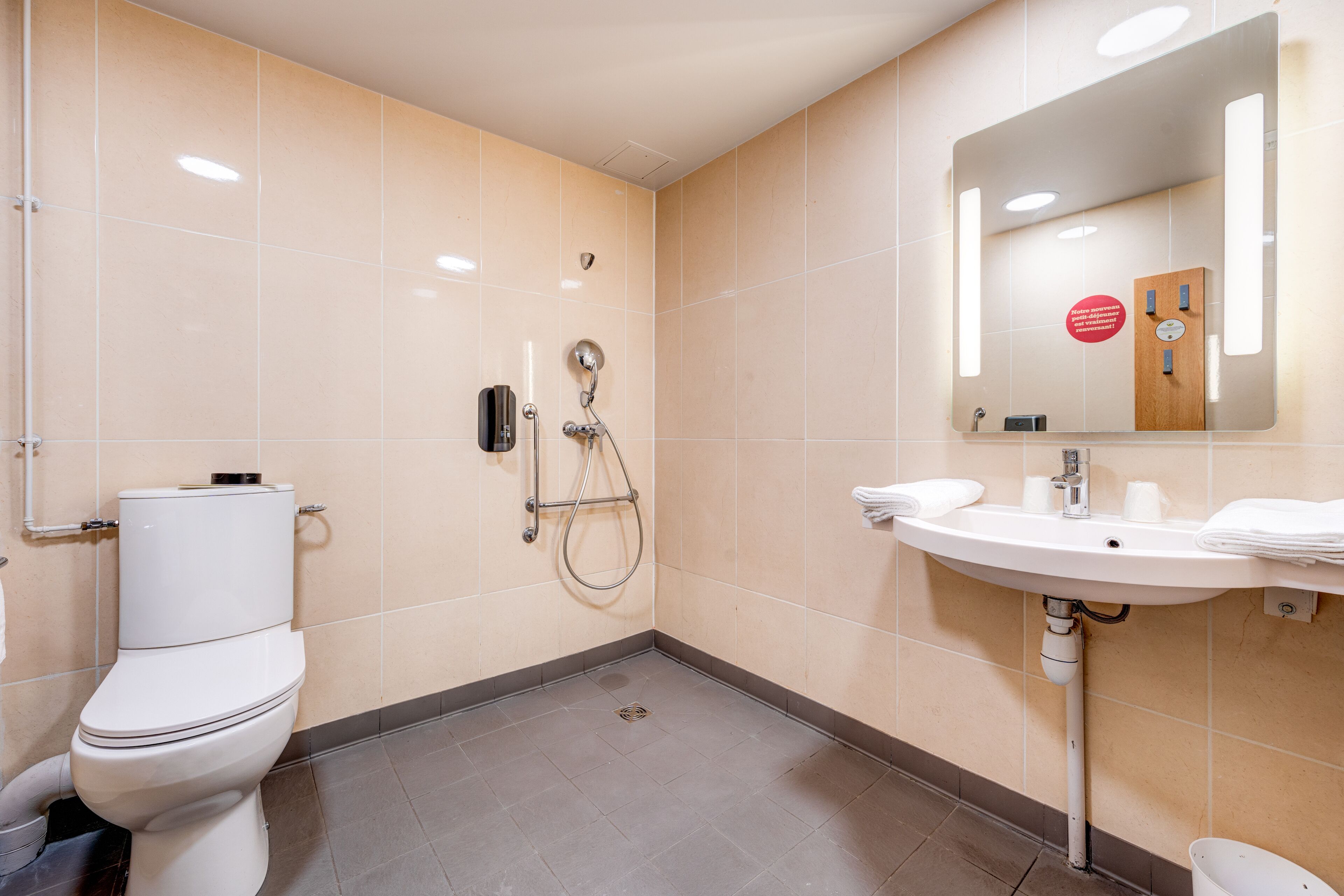 A modern bathroom with a toilet, shower, and sink.