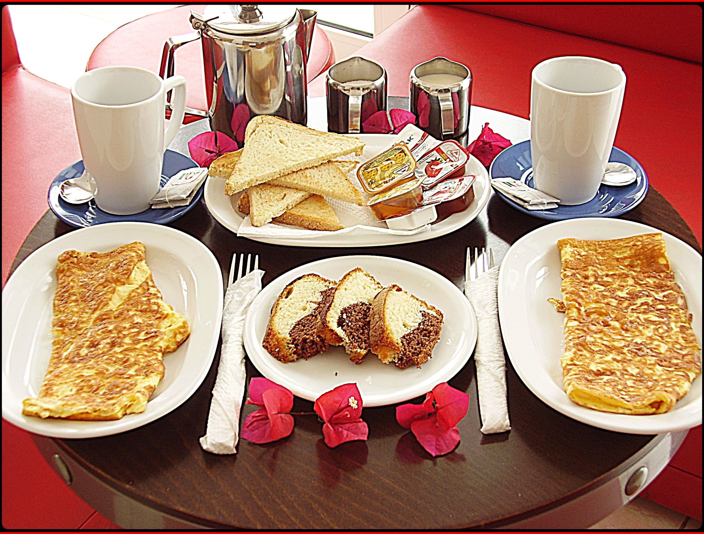 Een ontbijfwagen met toast, een plak cake en een omelet.