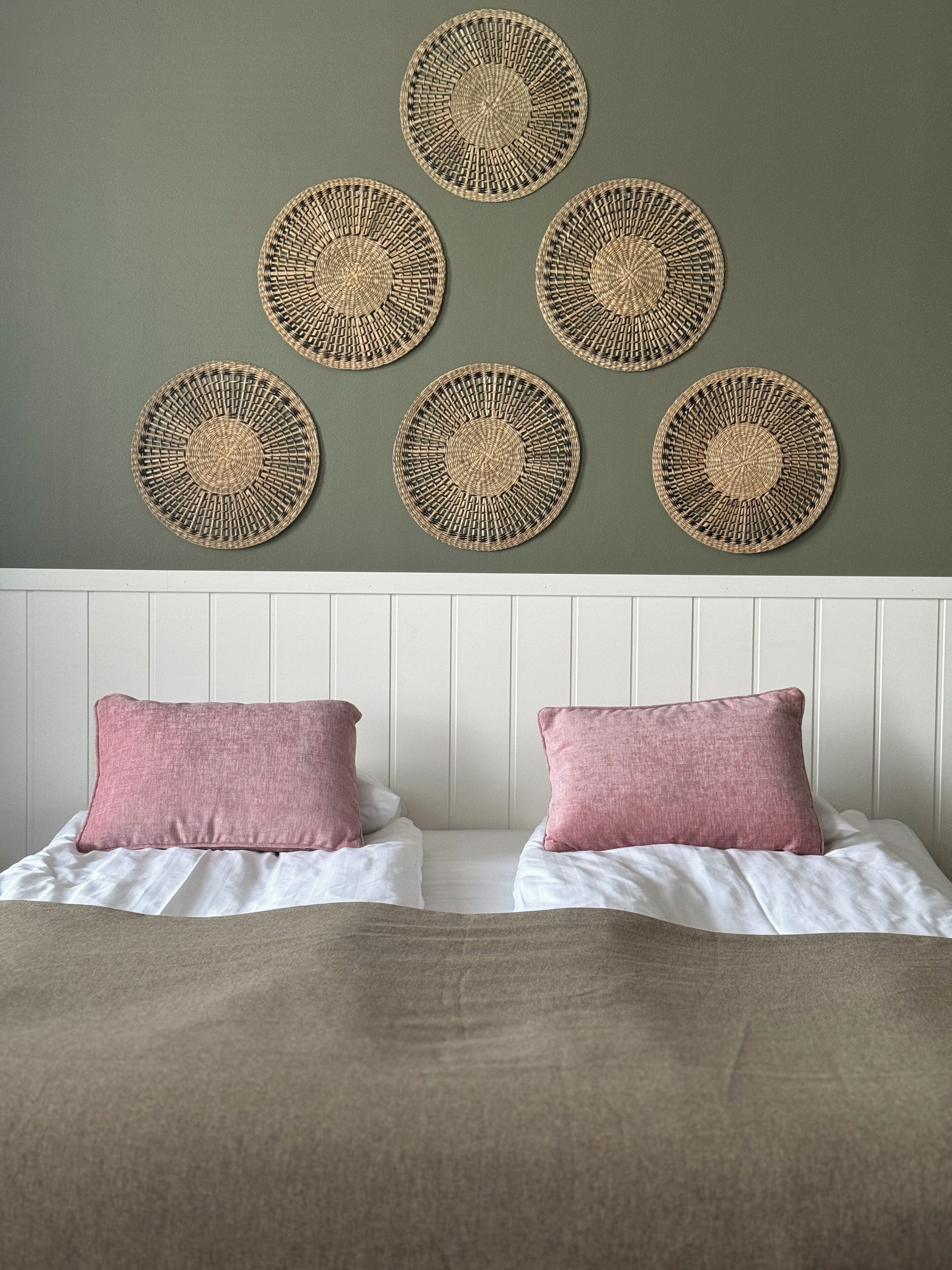 A bedroom with a bed, two pillows, and a headboard.