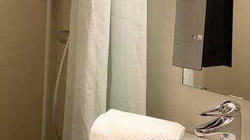 A bathroom with a white sink, a mirror, a shower curtain, and a towel.
