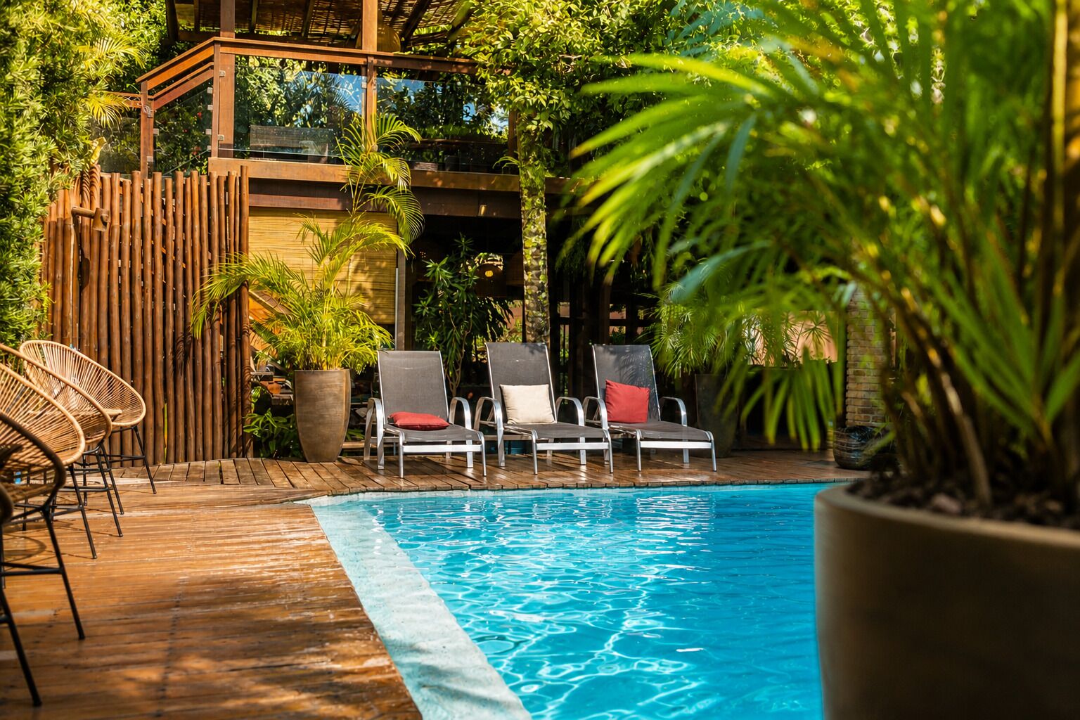 Un espace piscine avec des chaises longues et une terrasse en bois.