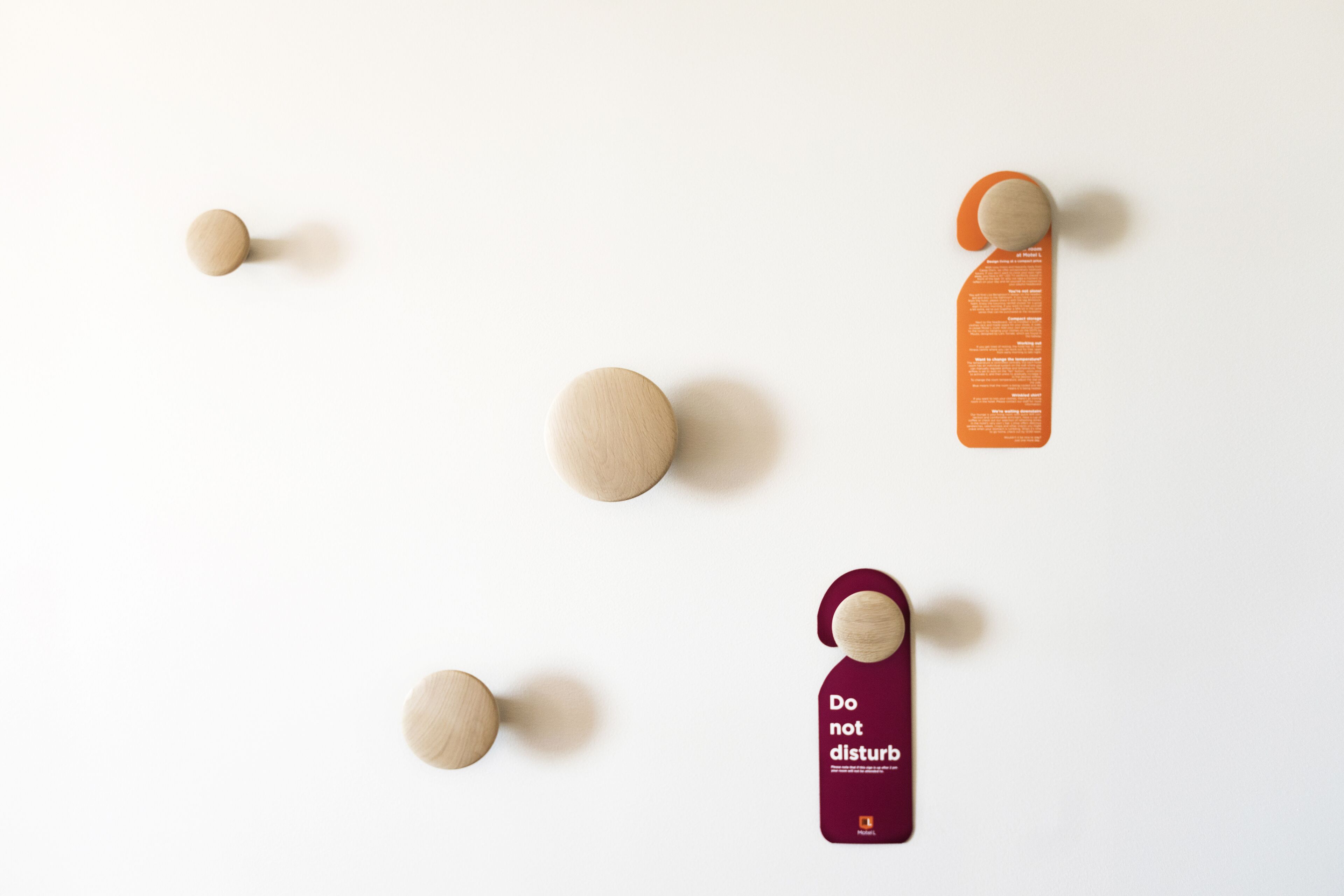 Diseño minimalista con esferas de madera y un colgador color burdeos.