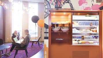 A modern interior with a seating area, a refrigerator stocked with beverages, and a mural on the wall.