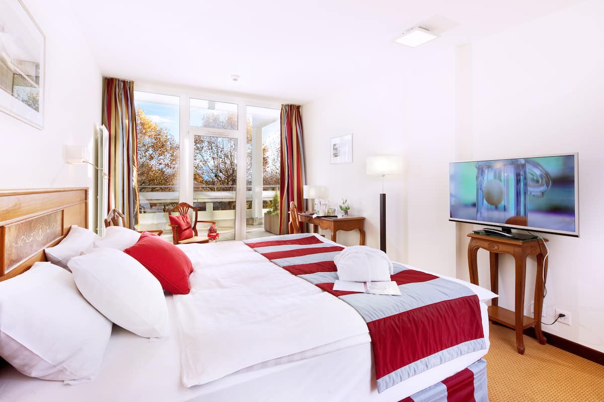 Une chambre d’hôtel avec deux lits, une télévision et une vue sur l’extérieur.