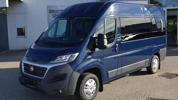 Una camioneta azul estacionada frente a un edificio con un letrero que dice "BRUGTS".
