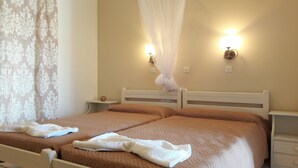 Una cama doble con dosel, dos mesitas de noche y una lámpara de pared.