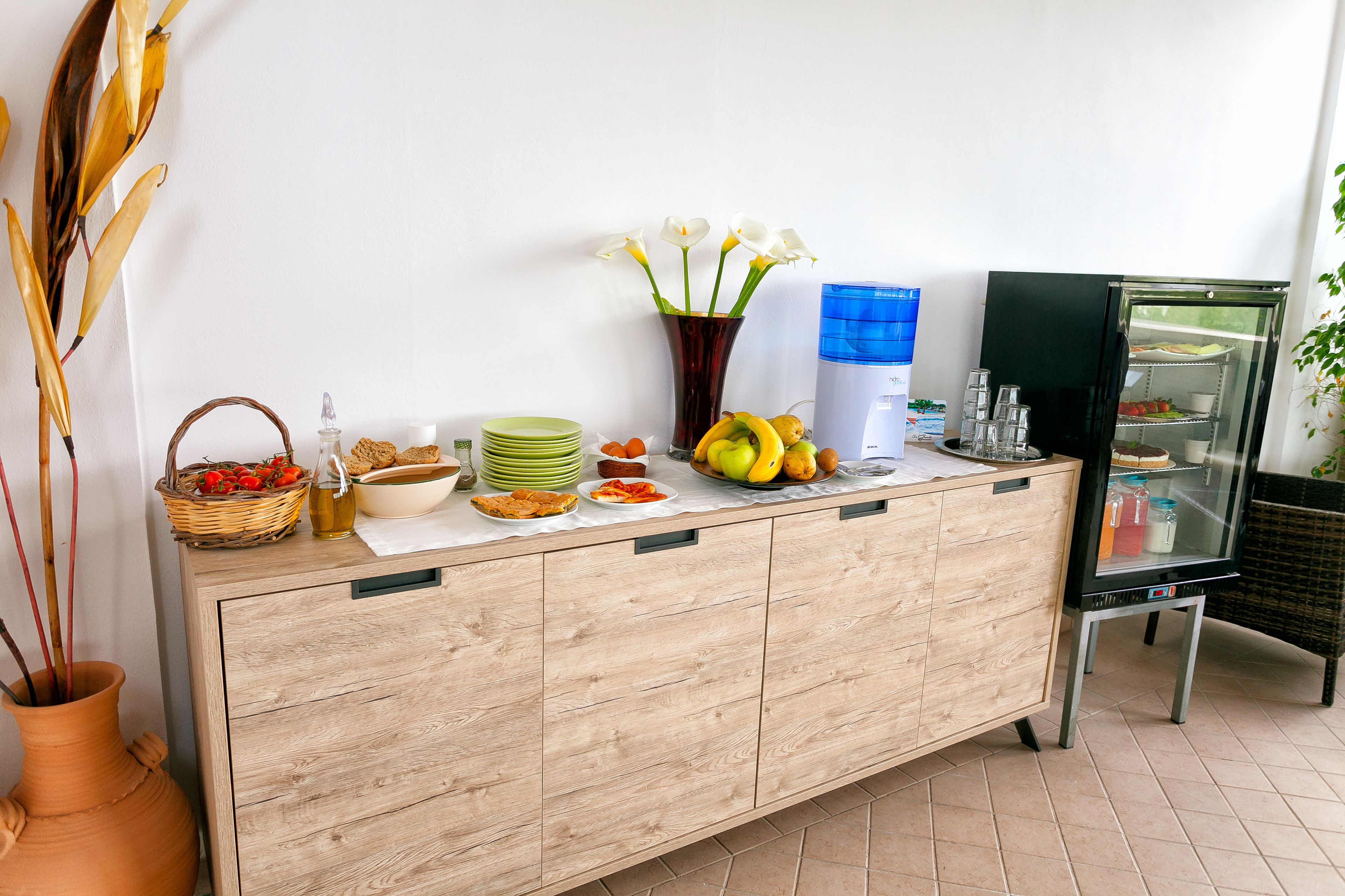 A buffet setup with various food items and a refrigerator.