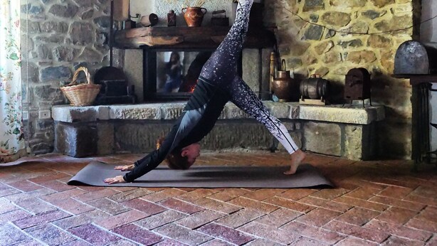 A yoga mat on a brick floor with a stone wall and shelves in the background. - Agriturismo Bio I Rondinelli (Arcidosso)