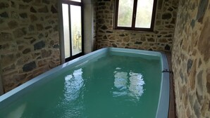 A stone-walled room with a rectangular bathtub filled with water. - Agriturismo Bio I Rondinelli (Arcidosso)