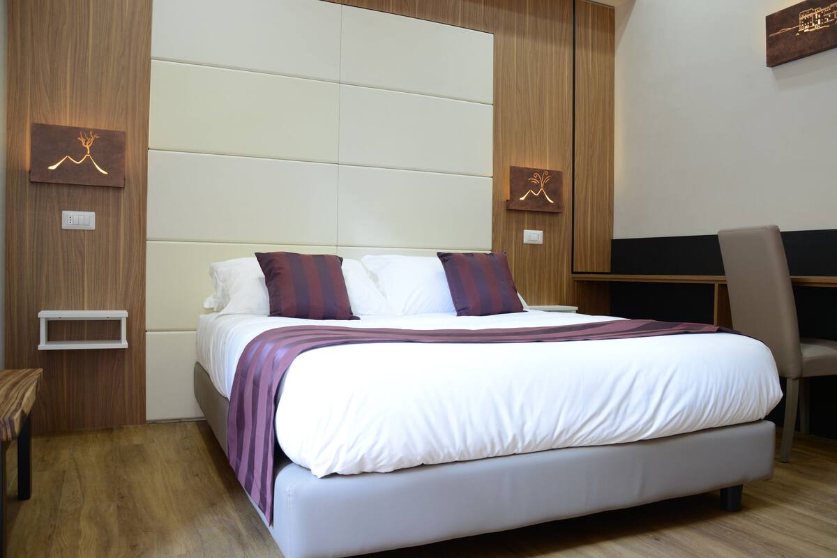 Ein modernes Schlafzimmer mit einem großen Bett, einem Schreibtisch und einem Stuhl.