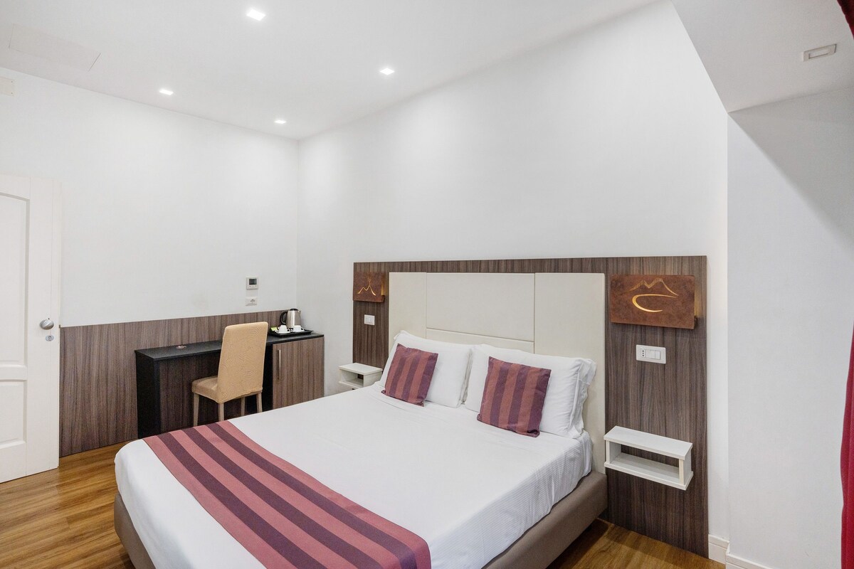 Una habitación de hotel moderna con una cama grande, un escritorio y una silla.