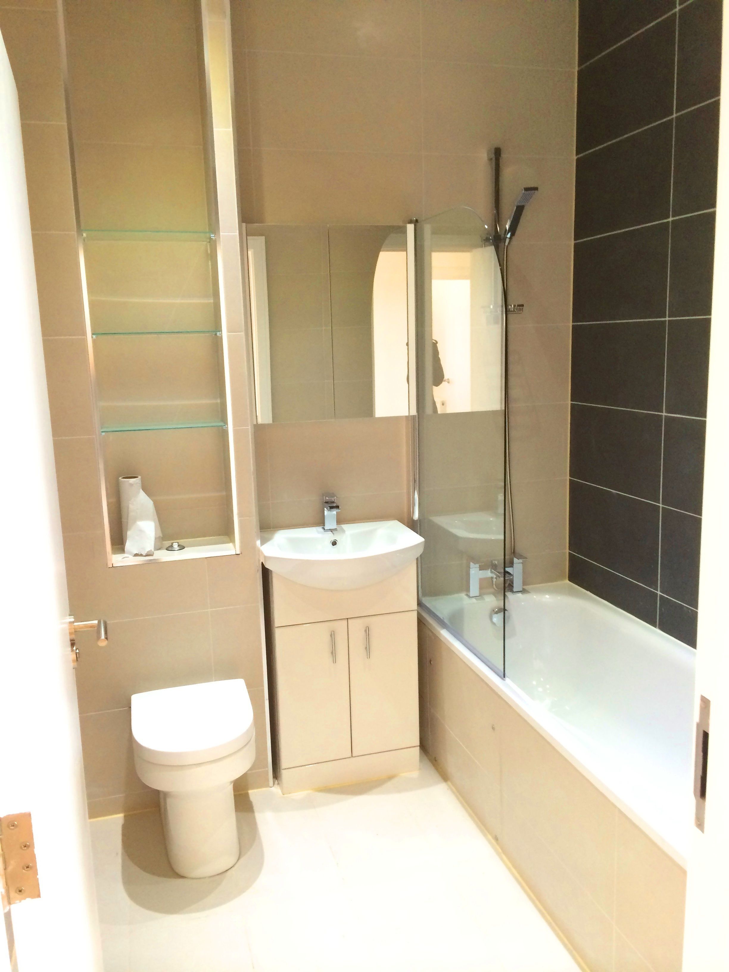 A modern bathroom with a toilet, sink, and bathtub.