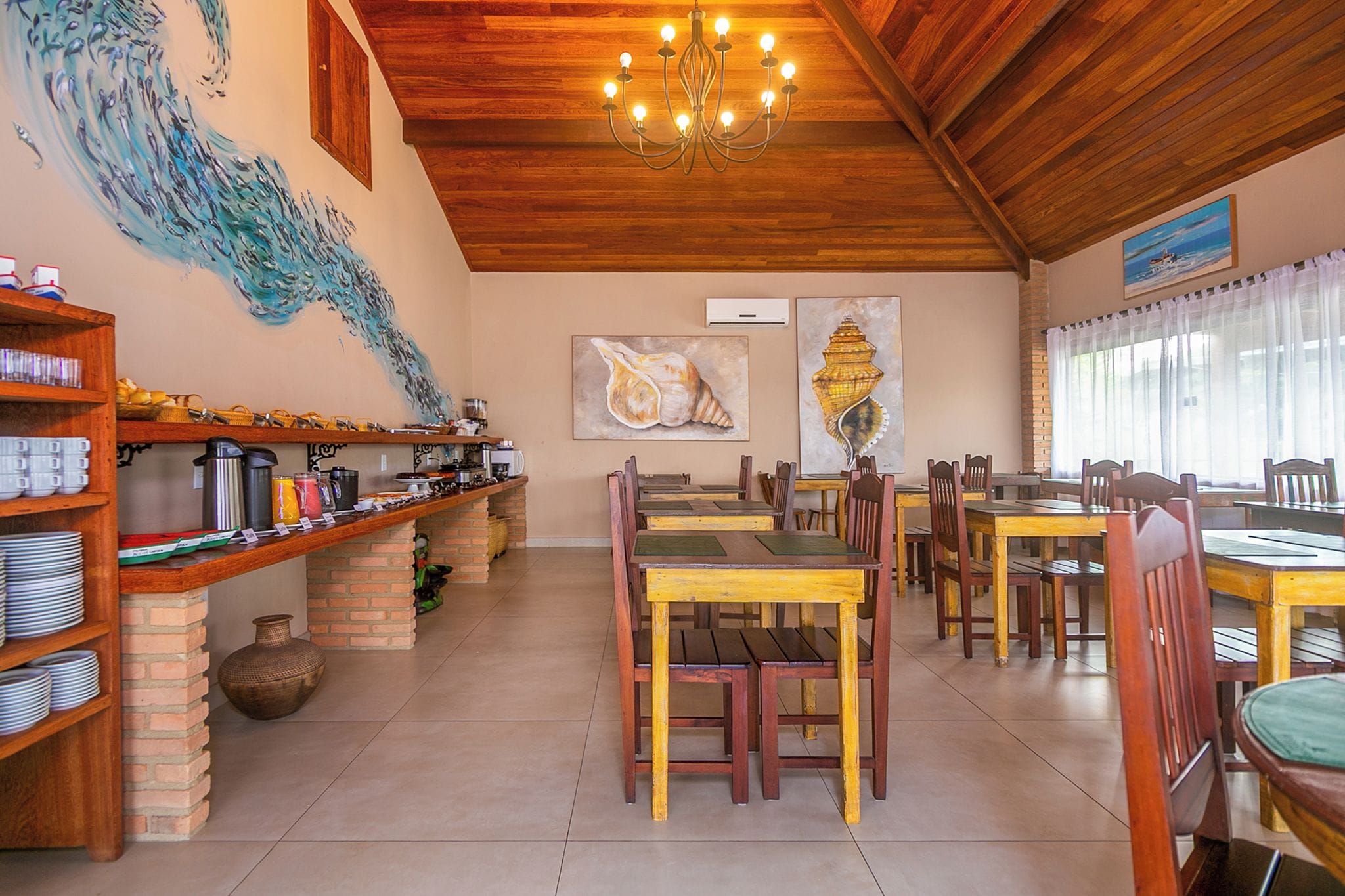 Un restaurante con techo de madera, un mural y una zona de bufé.