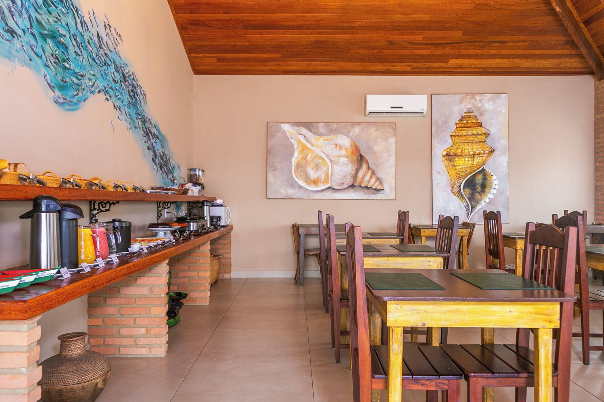 Ein Restaurant mit einer langen Theke, mehreren Sitzplätzen und Kunstwerken an den Wänden.