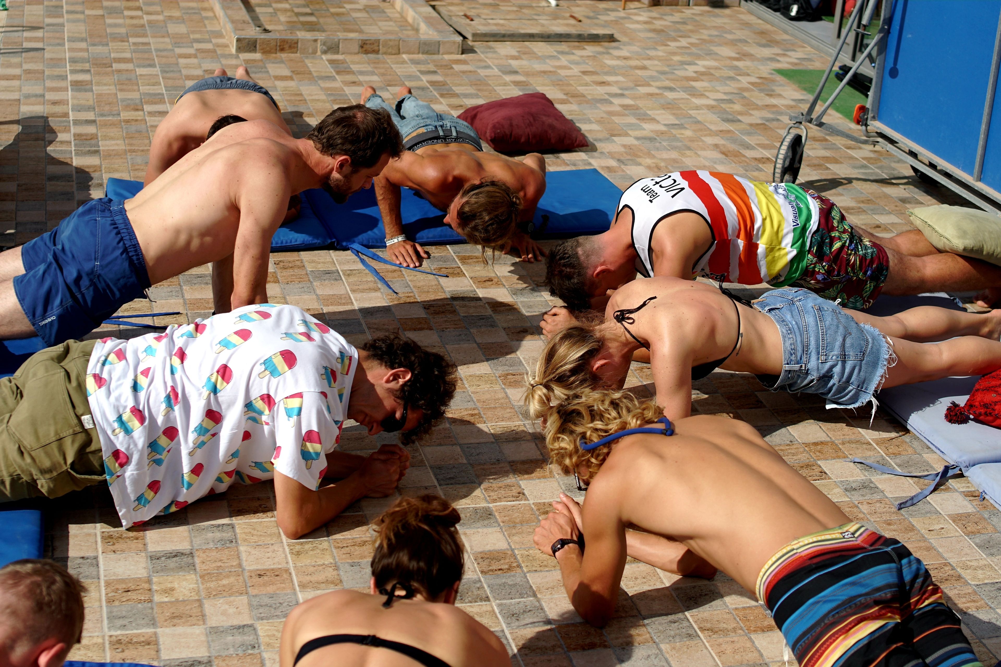 Een groep mensen die op een betegeld terras aan het zonnebaden is.