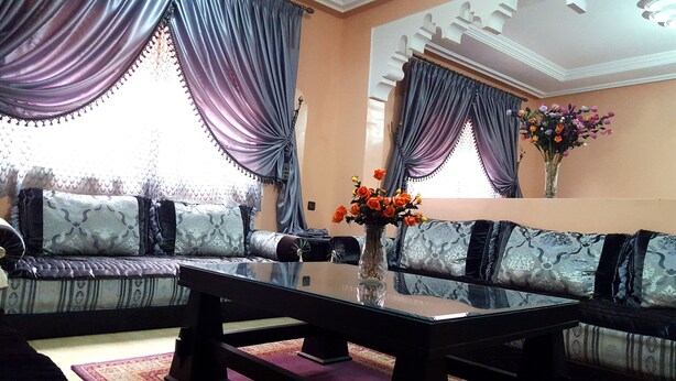 A room with a sofa set, a glass coffee table, and a vase with flowers. - Villa Annakhil Families And Couples (Marrakech)