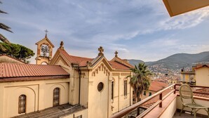A building with a bell tower and a balcony with a chair. - AwesHome - Sea Sensation Apartment (La Spezia)