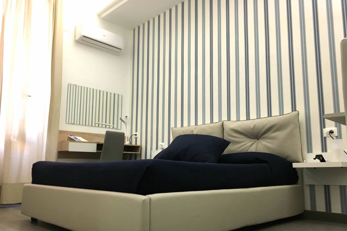 A modern bedroom with a bed, a desk, and a chair.