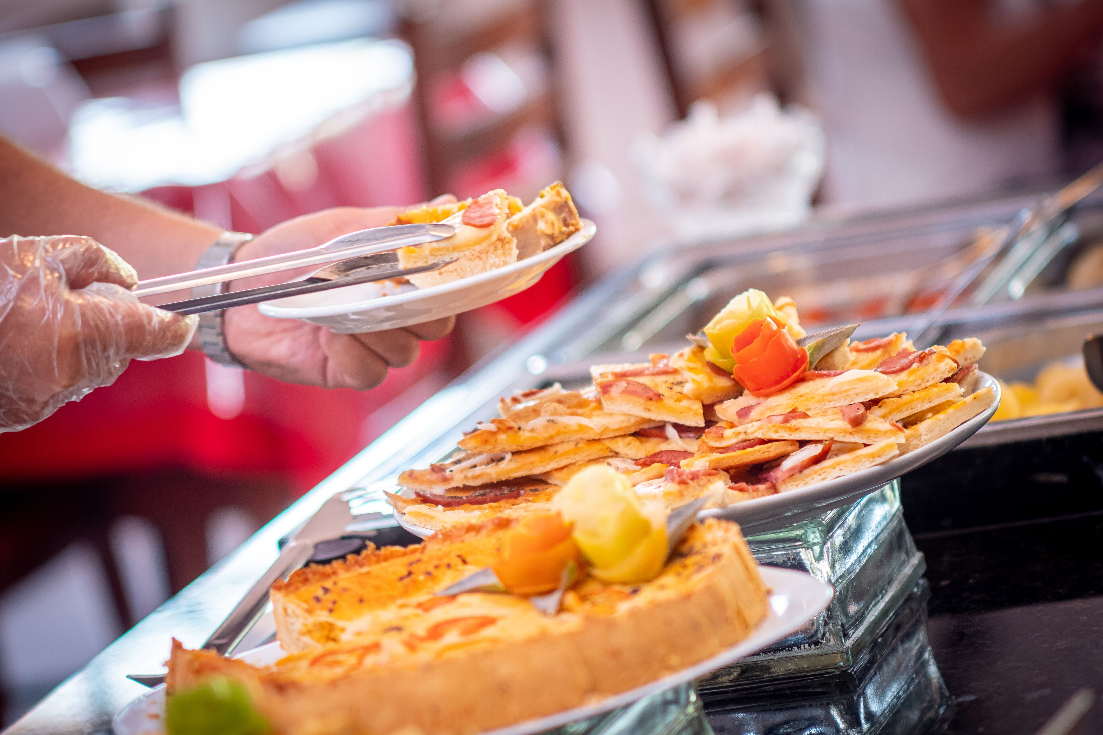 Buffet com diversos alimentos, incluindo pizza e bolo.