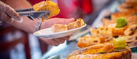 A person serving food from a buffet.