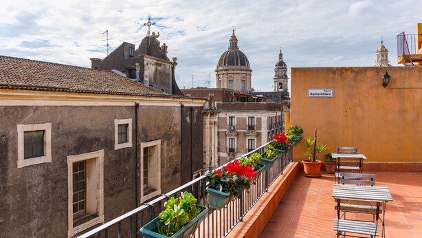 A terrace with potted plants and outdoor seating. - Terrazza Santa Chiara (Catania)