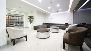 Una sala de estar moderna con un sofá modular, dos sillones y una mesita de centro.