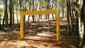Un’altalena gialla in una zona boschiva.