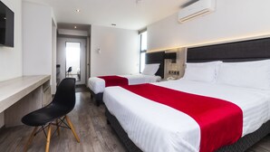A hotel room with two beds, a desk, a chair, and a TV. - Hotel Nube, Puebla Centro (Puebla)