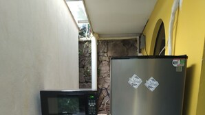Une cuisine compacte équipée d’un four à micro-ondes, d’une machine à café et d’un réfrigérateur.