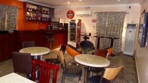 A bar area with a liquor display, a jukebox, and a 'No Smoking' sign. - AES Luxury Apartments (Lagos)